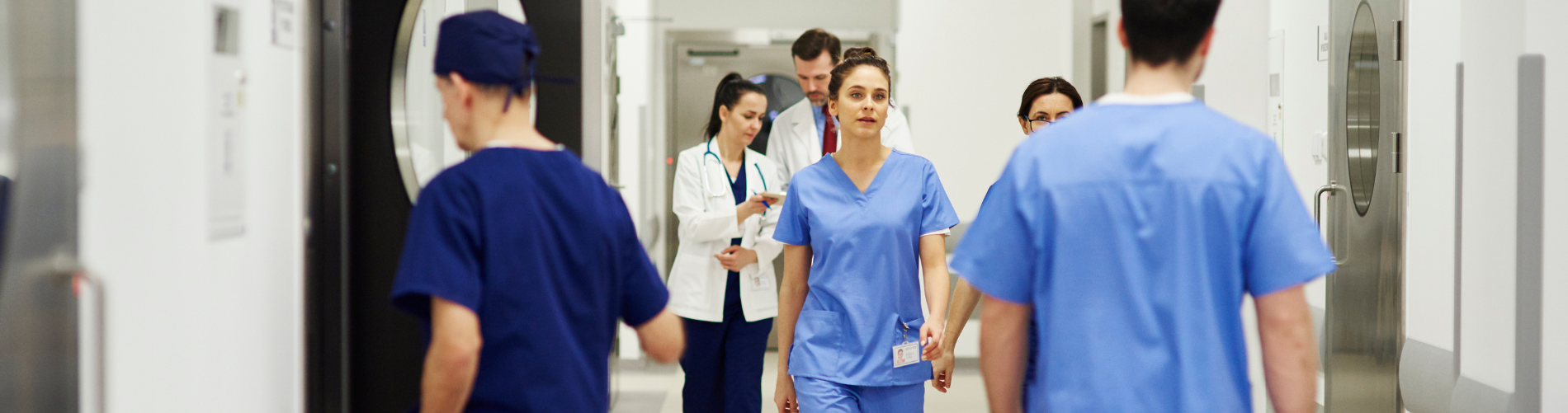 Pflegekräfte in einem Krankenhausflur, stellvertretend für den aktiven Arbeitsalltag in der Pflege.